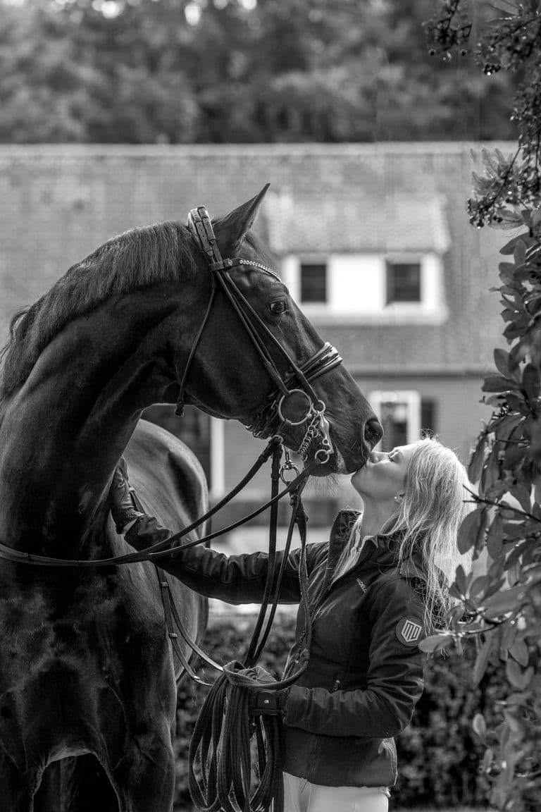 Ruiter geeft haar paard een kus voor de stallen